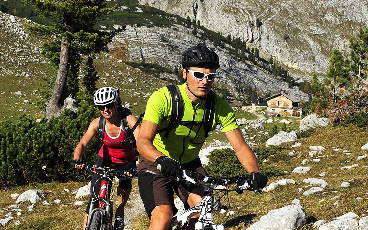 Una coppia durante un'escursione in mountain bike tra le Dolomiti