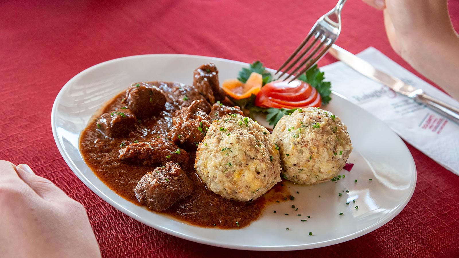 Ein Teller mit Knödeln und Gulasch